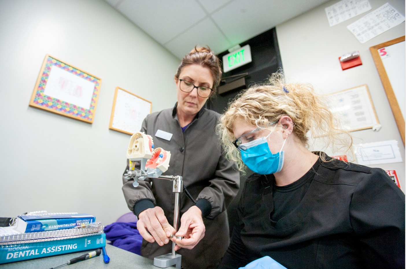 Instructor demonstrating for a dental assistant student